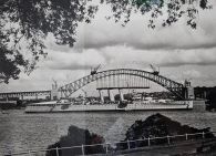 Photograph of HMAS Canberra I in 1930 in front of the Sydney Harbour Bridge