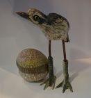 ceramic bird sculpture next to its egg