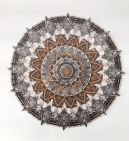intricate circular wooden object with 4 concentric circles and flower like petals emerging from each circle