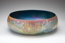 ceramic round pot with various colours which look like metal (copper), and a blue interior