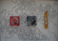 map of Canberra with 3 objects on top - red square with circle cut out, black square with line cut out and yellow rectangle shaped like a Stanley knife